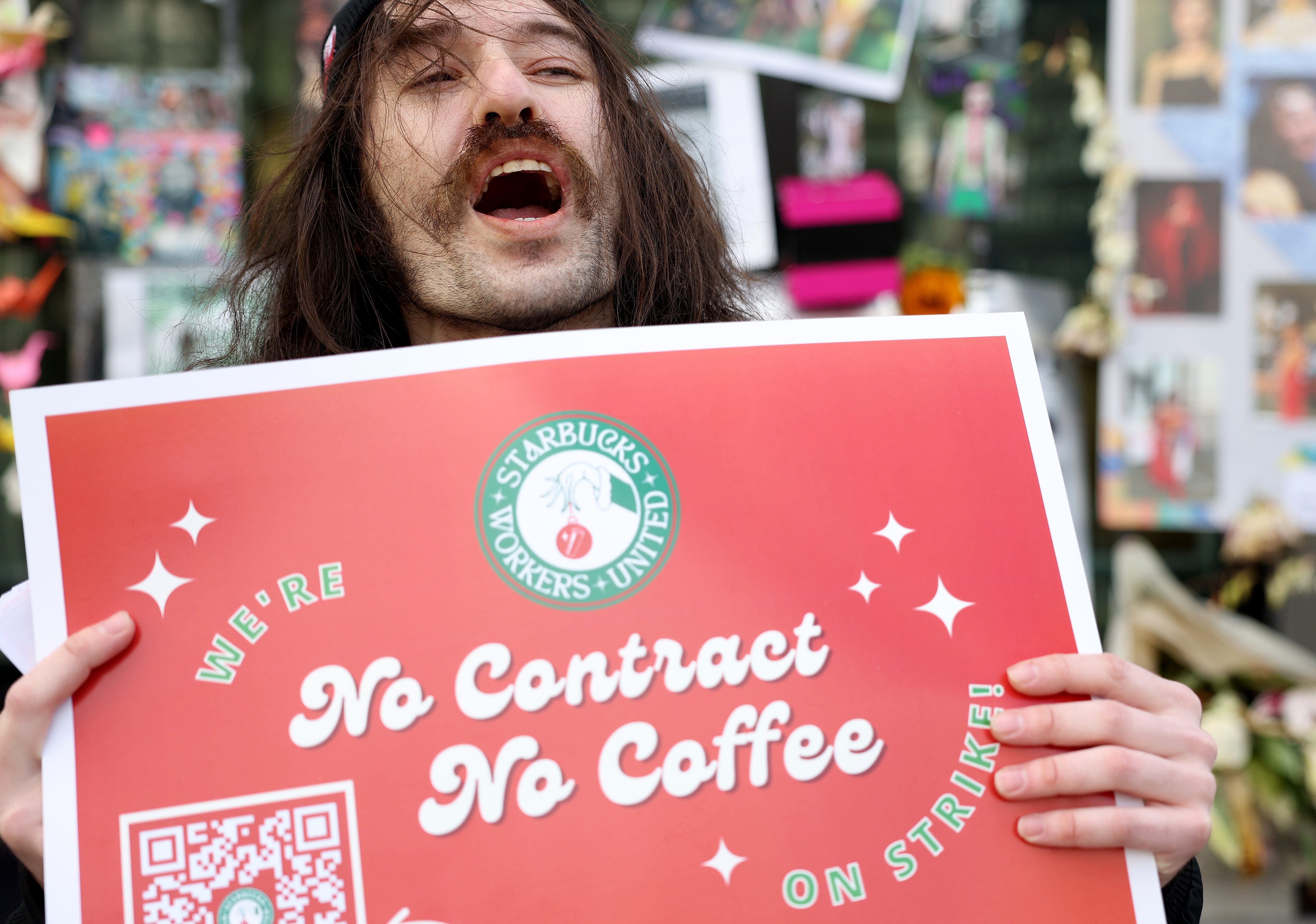 Striking Starbucks worker Kyle Trainer holds a sign outside of a Starbucks coffee shop during a national strike on Nov. 17, 2022, in San Francisco, California. Thousands of members of the Starbucks Workers Union are striking at over one hundred Starbucks stores across the country as workers try to negotiate a contract with Starbucks. The one-day strike is taking place on Red Cup Day, when Starbucks gives customers limited-edition reusable red holiday cups,   one of the company's most profitable days of the year.