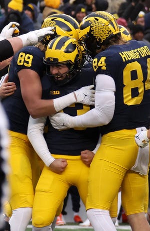 Jake Moody (13) of the Michigan Wolverines celebrates his game winning field goal late in the fourth quarter with teammates while playing the Illinois Fighting Illini at Michigan Stadium on November 19, 2022 in Ann Arbor, Michigan.