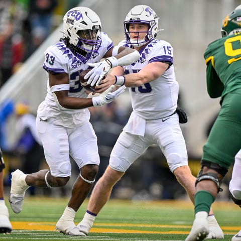 TCU quarterback Max Duggan (15) hands off to runni