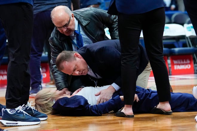 Nov 20, 2022; Hartford, Connecticut, USA; Connecticut Huskies associate head coach Chris Dailey is attended to after collapsing on the court during pregame ceremonies against the North Carolina State Wolfpack at XL Center. Mandatory Credit: Gregory Fisher-USA TODAY Sports