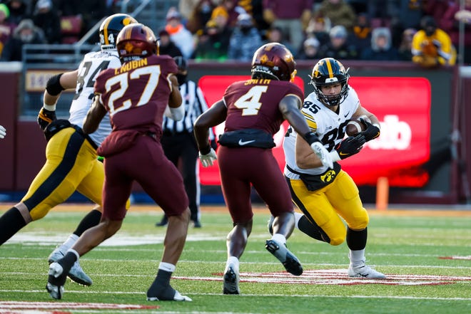 Iowa tight end Luke Lachey runs with the ball while Minnesota's Terell Smith (4) defends in the first quarter of Saturday's game in Minneapolis.