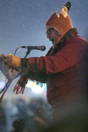Rob Otto, author of "The Puppy in the Red-Checkered Coat Meets Santa," reads at the Brighton Holiday Glow and Christmas Market Saturday, Nov. 19, 2022, from the book inspired by Otto's attendance at the annual event with a rescue dog years ago.