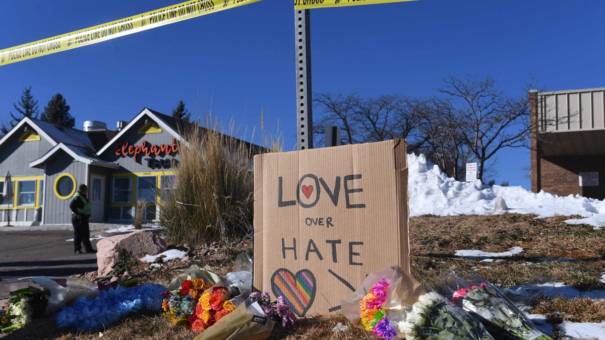 Bouquets of flowers and a sign reading "Love Over Hate" are left near Club Q, an LGBTQ nightclub in Colorado Springs, Colorado, on November 20, 2022. - At least five people were killed and 18 wounded in a mass shooting at an LGBTQ nightclub in the US city of Colorado Springs, police said on November 20, 2022. 