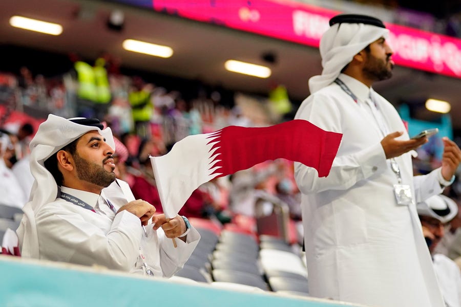 Nov 20, 2022; Al Bayt, Qatar; A fan waves a Qatar flag before a group stage match during the 2022 FIFA World Cup between Qatar and Ecuador at Al Bayt Stadium.