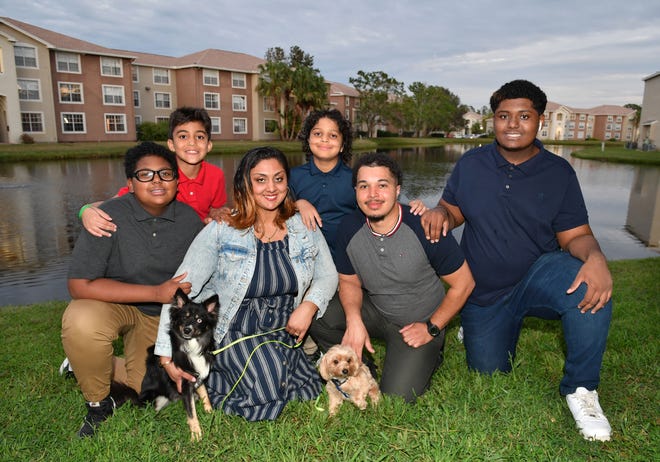 Rishana and Michael Dawkins, with their boys, from left, Samar, 13, Adriel, 9, Gabriel, 7, and Amir, 15, with their dogs, Storm and Chewbacca at the Lakes at North Port apartment complex where they were fortunate to find a rental after their home flooded following Hurricane Ian.