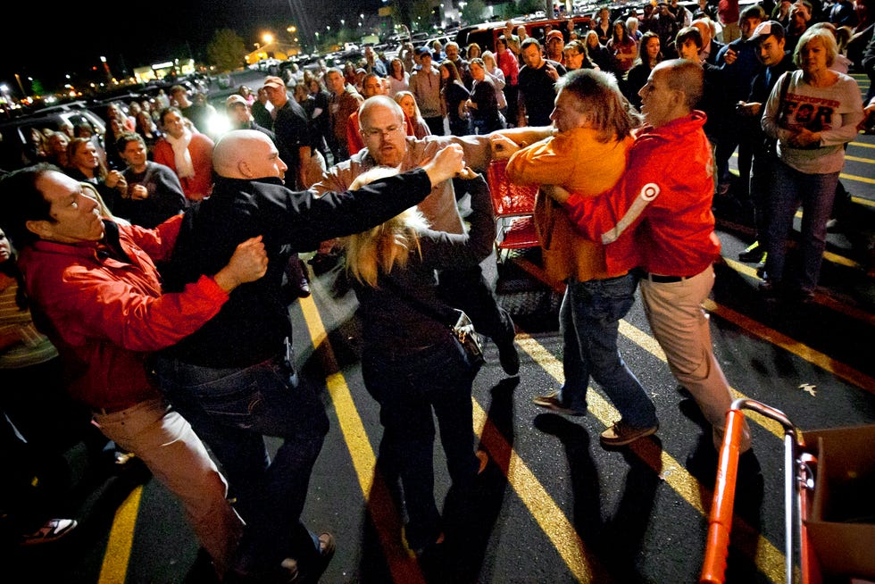 Security guards break up a fight between shoppers waiting in line just as the doors open for Black Friday 2012 in Bowling Green, Ky.