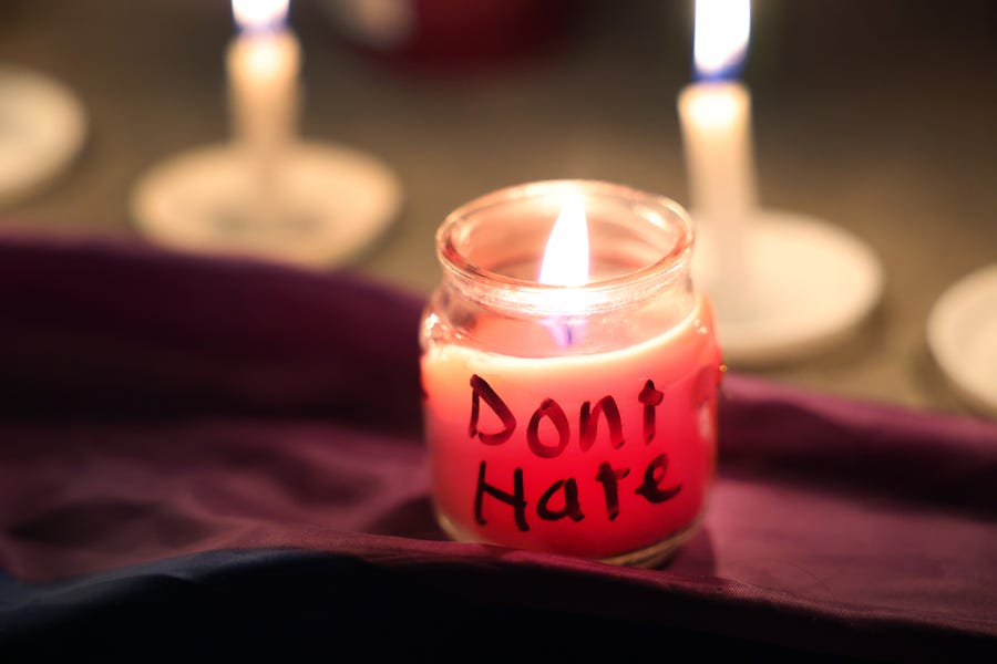 A candle with a message burns at a makeshift memorial near the Club Q nightclub on November 20, 2022, in Colorado Springs, Colorado. Yesterday, a 22-year-old gunman entered the LGBTQ nightclub opened fire, killing at least five people and injuring 25 others before being stopped by club patrons.