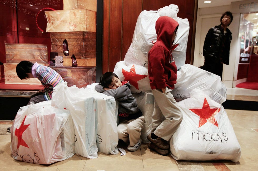 Children wait with shopping bags inside Macy's department store on Black Friday Nov. 26, 2010 in New York City.