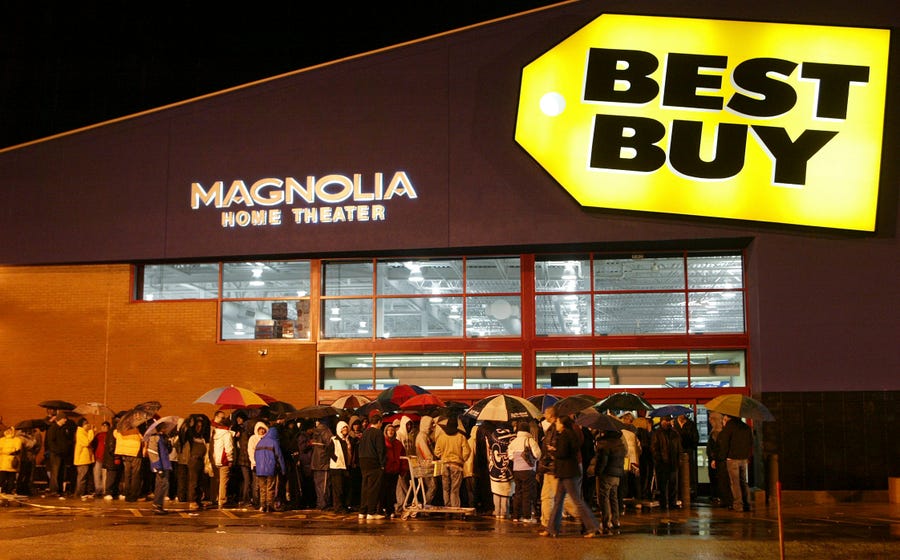Holiday shoppers stand in line in the rain outside a Best Buy in Warwick, R.I., waiting for the doors to open at 5:00 a.m., for Black Friday deals, in this Nov. 24, 2006.