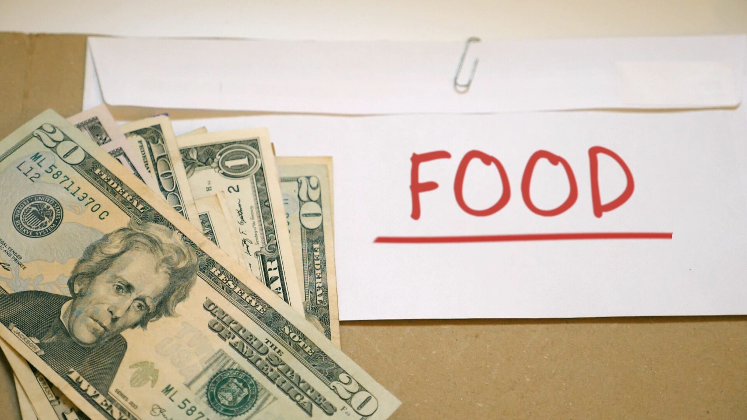 Money sits atop an envelope labeled "food."