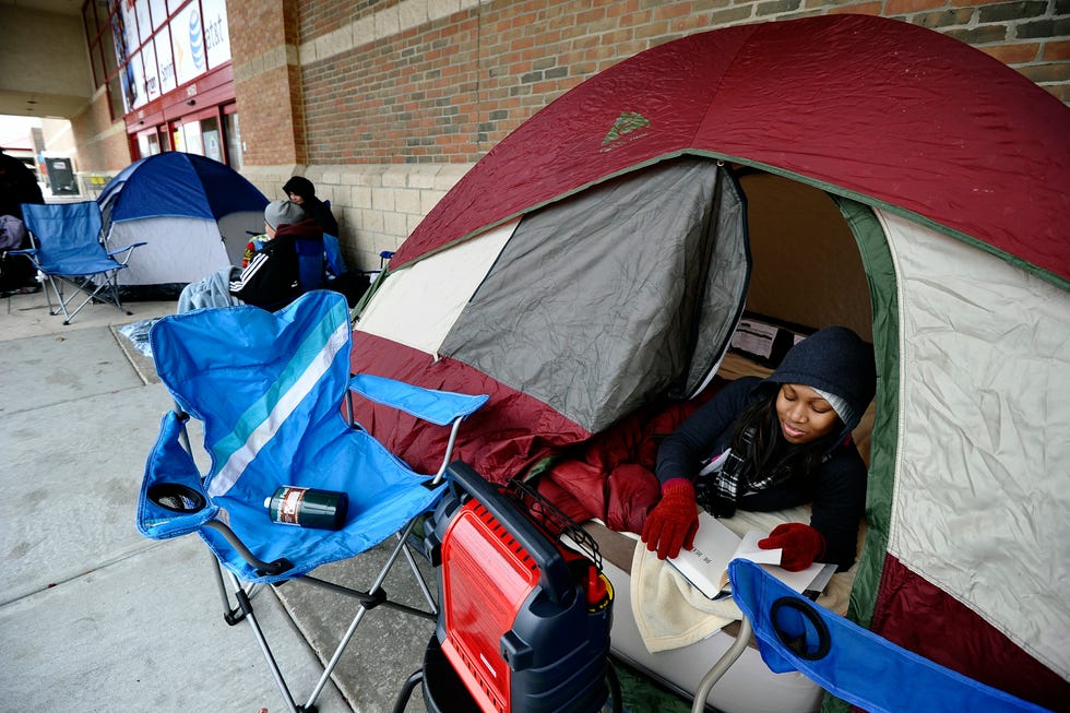 Lauren Arnold reads a book in her tent as she lines ups with others outside a BestBuy store in Laurel, Maryland, on November 25, 2010 for "Black Friday" shopping.