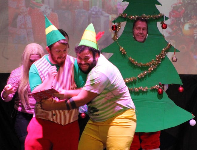 Buddy the Elf, played by Ian J. Diaz-Ortega, hugs the mall manager played by Micah Bachert during a Monday night rehearsal for “Elf the Musical” at the Flag Theatre. Scott Maxwell is playing the Christmas Tree. 
Audrey Fox, playing Jovie, is in the background. The Family Community Theatre production of “Elf the Musical,” directed by JoJoDutton, will play Friday through Sunday and Dec. 1-4. The Flag Theatre is located at 310 North Main, Hutchinson.
