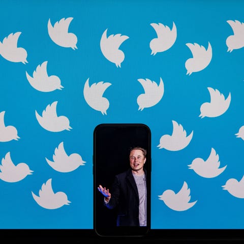 Elon Musk shown on a cellphone that's leaning agai