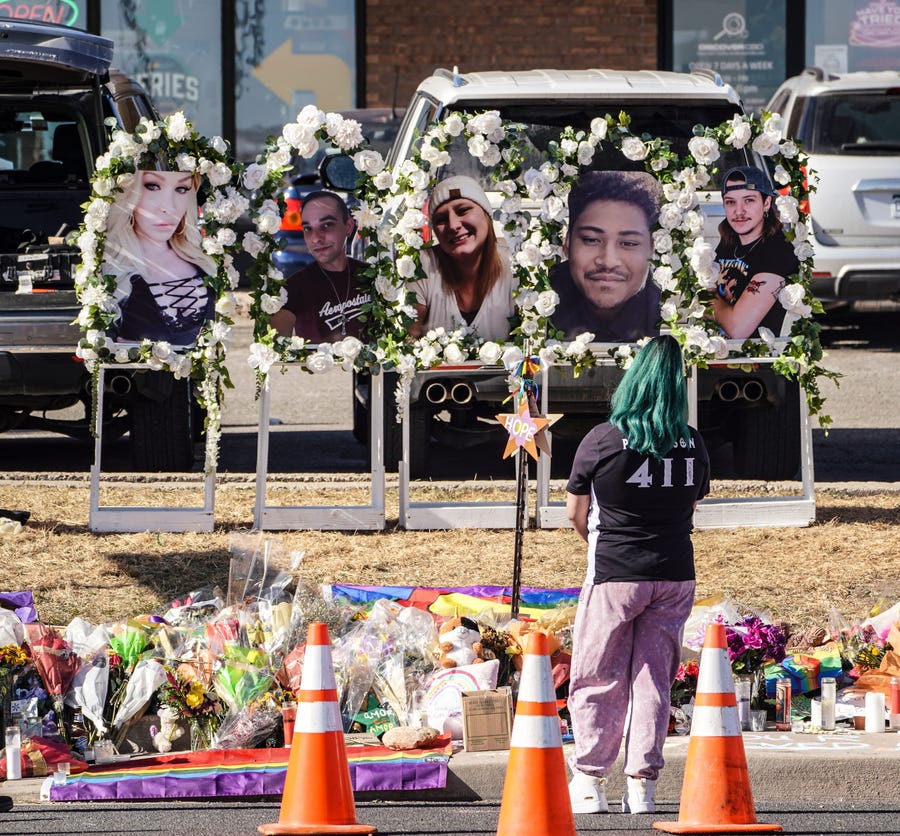 People pay their respects at a memorial display set up to remember the five victims of the Club Q shooting in Colorado Springs, Colorado, on Tuesday, Nov. 22, 2022.