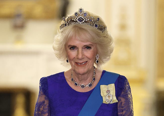 Queen Consort Camilla poses before attending the State Banquet (the first of the new reign of King Charles III) for South Africa President Cyril Ramaphosa at Buckingham Palace on Nov. 22, 2022. She wore a lace gown by Bruce Oldfield and the late Queen Elizabeth II's Belgian Sapphire Tiara of sapphires and diamonds.