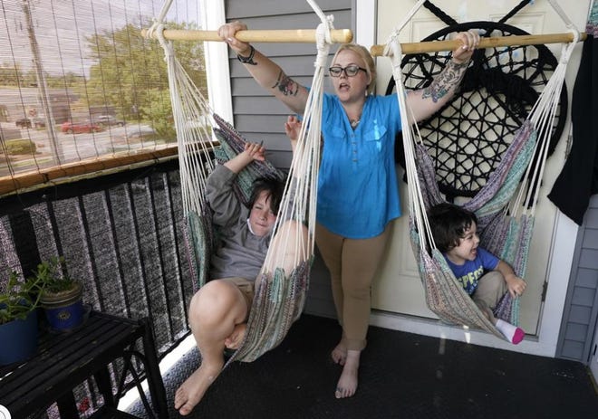 In this July 28, 2021, photo Christina Darling plays with her sons Kayden, 10, left, and Brennan, 4, at home in Nashua, N.H. Darling and her family qualified for the expanded tax credit, part of President Joe Biden's $1.9 trillion coronavirus relief package. "Every step we get closer to livable wages is beneficial," said Darling, who makes $35,000 a year as a housing resource coordinator. Congress let the credit expire in December of 2022.