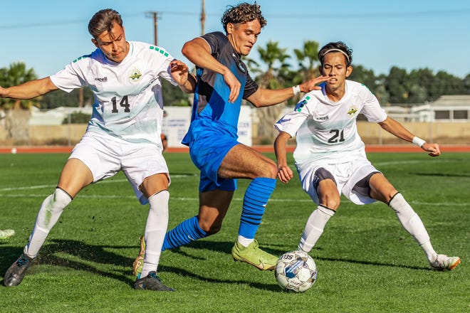 Oxnard College freshman defender Emmanuel Solis moves through two opponents Tuesday afternoon in the CCCAA Southern California regional semifinal against visiting Golden West College.  Oxnard won the match 3-0.