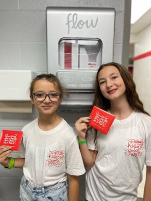 Lindse Barks' daughters, sixth grader Jo (left) and eighth grader Charlee hold period products at their school in Oklahoma.