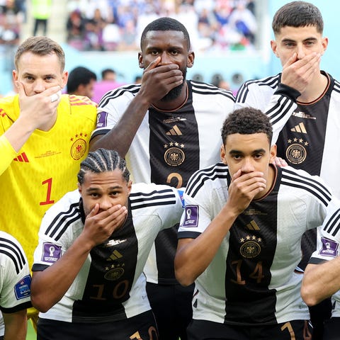 Germany players pose with their hands covering the