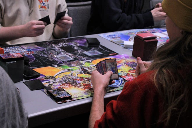 Two players battle in a card game Sunday at Rogue Games, 533 E. Walnut St., in downtown Green Bay. The new gaming store also offers space for tournaments and tables to play.
