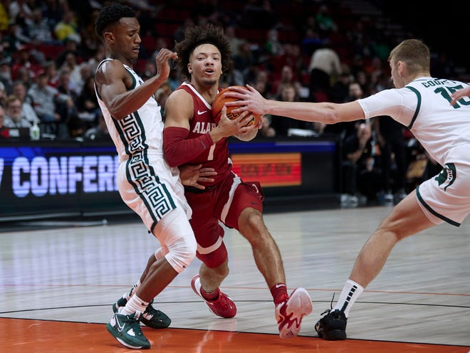 Alabama guard Mark Sears, center, drives to the basket between Michigan State guard Tyson Walker, left, and center Carson Cooper during the first half of an NCAA college basketball game in the Phil Knight Invitational tournament in Portland, Ore., Thursday, Nov. 24, 2022. (AP Photo/Craig Mitchelldyer)
