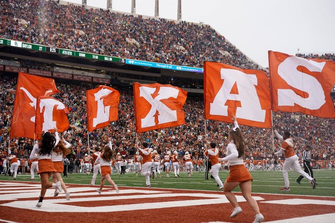 Texas spirit squad members carry flags as they run through the end zone at Royal-Memorial Stadium after a UT touchdown against Baylor last season. This fall will be the final football season in the Big 12 for Texas, which, along with Oklahoma, will join the SEC in July 2024.