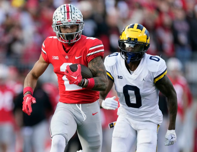 Nov 26, 2022; Columbus, OH, USA; Ohio State Buckeyes wide receiver Emeka Egbuka (2) comes up with a catch against Michigan Wolverines defensive back Mike Sainristil (0) in the fourth quarter of their game at Ohio Stadium. 