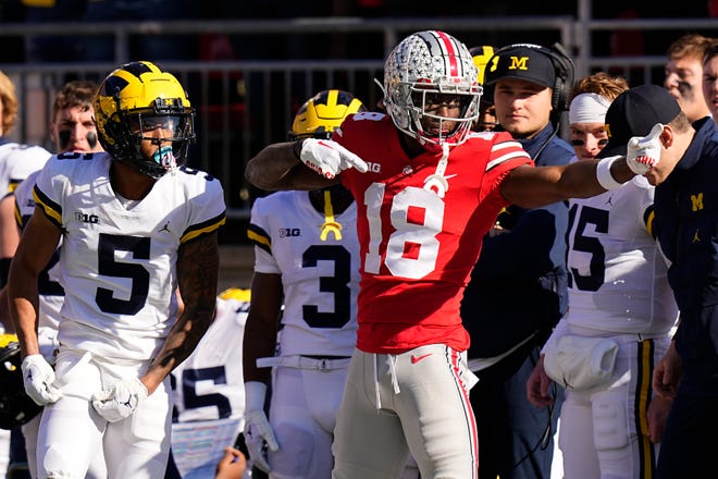Nov 26, 2022; Columbus, Ohio, USA;  Ohio State Buckeyes wide receiver Marvin Harrison Jr. (18) celebrates a first down in front of Michigan Wolverines defensive back DJ Turner (5) during the first half of the NCAA football game at Ohio Stadium. Mandatory Credit: Adam Cairns-The Columbus Dispatch
