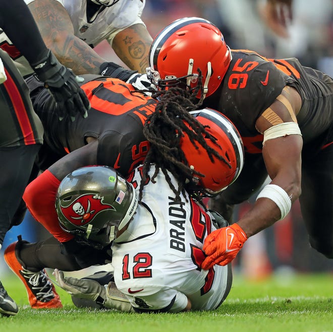 Buccaneers quarterback Tom Brady is sacked by Browns defensive ends Jadeveon Clowney, left, and Myles Garrett (95) during the second half, Sunday, Nov. 27, 2022, in Cleveland.