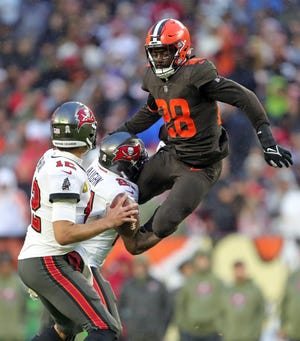 Browns linebacker Jeremiah Owusu-Koramoah attempts to leap over Buccaneers running back Ke'Shawn Vaughn as he attempts to get to quarterback Tom Brady during the second half, Sunday, Nov. 27, 2022, in Cleveland.