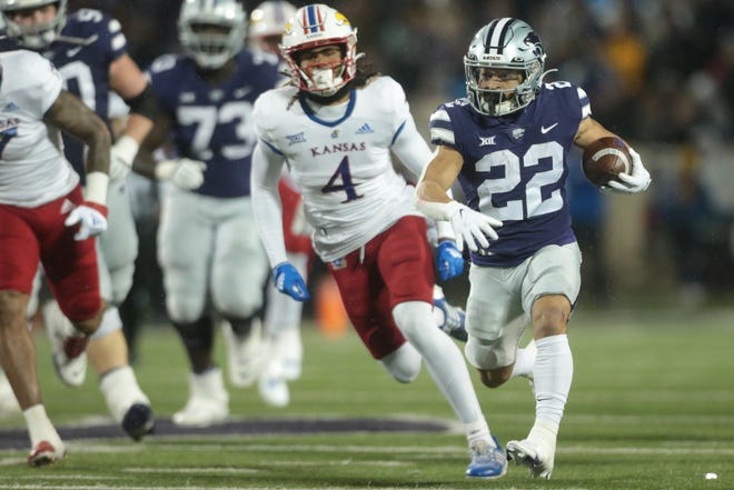 Kansas State running back Deuce Vaughn (22) runs past Kansas safety Marvin Grant (4) during the first quarter on Saturday night at Bill Snyder Family Stadium. Vaughn rushed for 147 yards and a touchdown in the Wildcats' 47-27 victory.