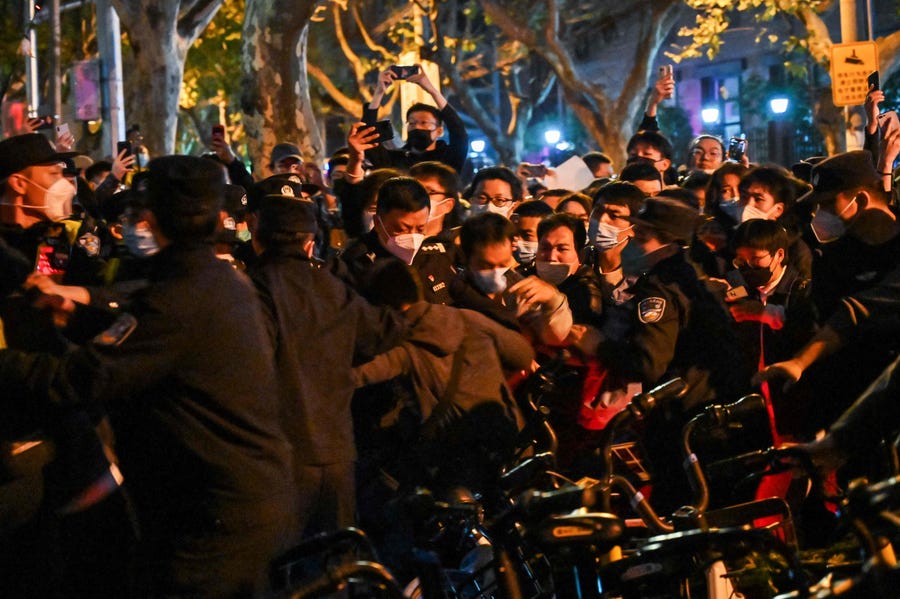 Police and people are pictured during some clashes in Shanghai on November 27, 2022, where protests against China's zero-Covid policy took place the night before following a deadly fire in Urumqi, the capital of the Xinjiang region.