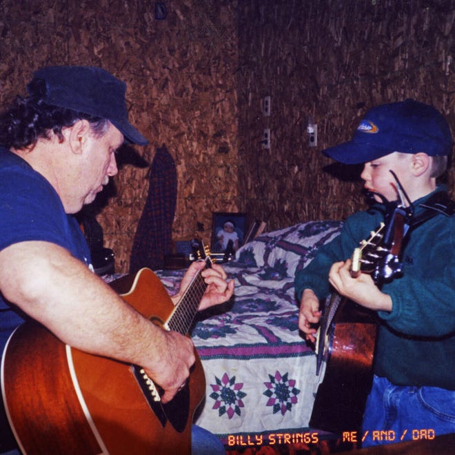 Billy Strings plays guitar with his stepdad, Terry Barber.