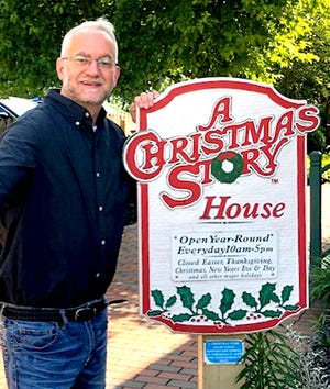 David T. Farr stands next to the sign for the home and museum for “The Christmas Story in Cleveland.