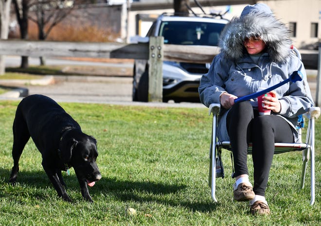 Kayla Coonan of Worcester discovered that she could not decide whether to keep her parka on as the weather Monday morning repeatedly went from cold and windy to sunny and pleasant as she played fetch at Kendrick Field with her dog, Tatum.