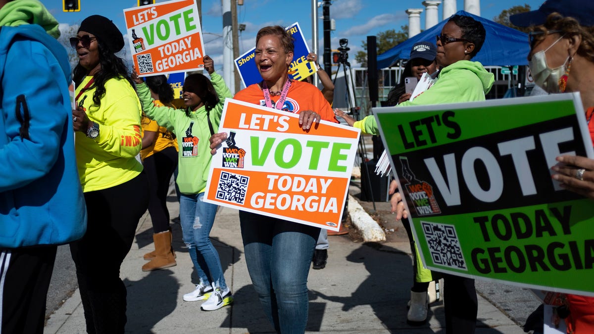 People gather during a get out the vote rally Sunday, Nov. 27, 2022, in Atlanta, during early voting for the Senate runoff election.