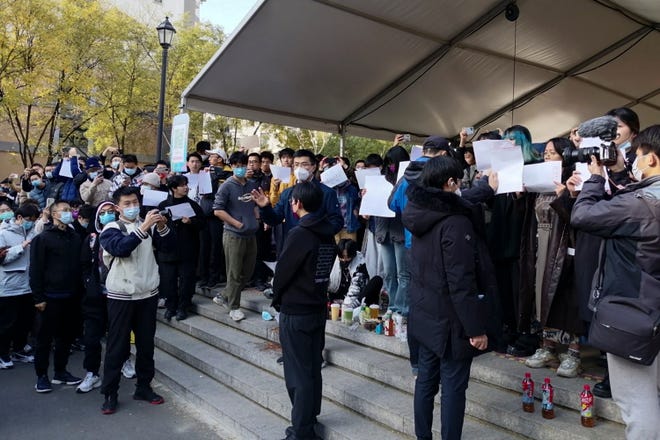 在这张拍摄于 2022 年 11 月 27 日星期日的照片中，学生们在中国北京的清华大学举行抗议活动。 官员放宽了分散地区的防病毒规定，但确认中国最严格 "零新冠病毒" 周一，在抗议限制令数百万人被困在家中的限制措施中，人群呼吁习近平辞职，此举出台。