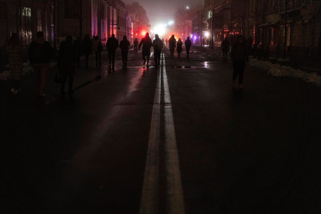 People walk through the city center which lost electrical power after a Russian rocket attack in Kyiv, Ukraine, Nov.  24, 2022.