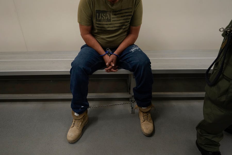 An immigrant considered a threat to public safety and national security waits to be processed by U.S. Immigration and Customs Enforcement agents at the ICE Metropolitan Detention Center in Los Angeles, after an early morning raid, June 6, 2022.
