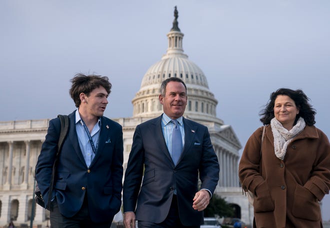 Adam Frisch of Aspen, Colo., center, the Democrat who opposed Rep. Lauren Boebert, R-Colo., in Colorado's 3rd Congressional District, walks with his son Felix Frisch, left, and wife Katy Frisch, right, at the Capitol in Washington, Friday, Nov. 18.
