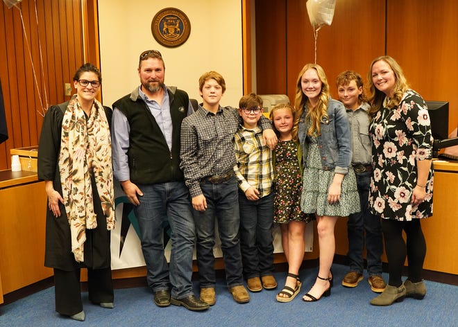 The Robinson family from Blissfield is pictured Tuesday, Nov. 29, 2022, in Lenawee County Probate Judge Catherine A. Sala's courtroom after Sala granted parents Reggie, second from left, and Brittney, far right, adoption rights to Jayson Allen Elliott-Klump, 13, third from left, and Jett Michael Elliott-Klump, fourth from left. Also pictured are, Rene, 7, Brooke, 15, and Zach, 12.