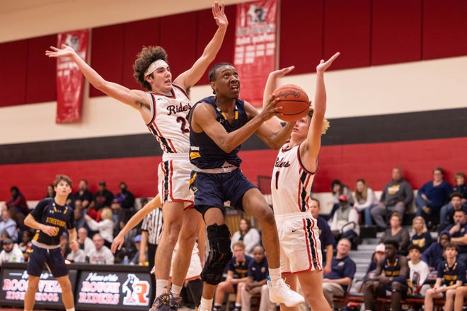 Streetsboro guard Brevyn Nobles cuts between Kent Roosevelt defenders Gavin Leslie and Nick Shannon to the basket during Tuesday night’s basketball game at Kent Roosevelt High School.