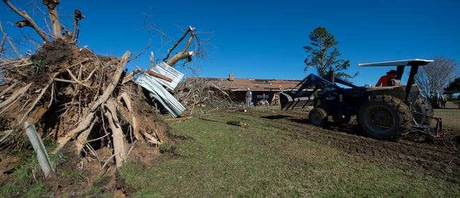 Family and friends clear a huge pecan tree, thought to be about 100 years old, off of the home of Robert and Brenda Burdine in the Mathiston community in Choctaw County, Miss., Wednesday, Nov. 30, 2022. A storm front moved through the state Tuesday into early Wednesday causing tornadoes throughout the state.