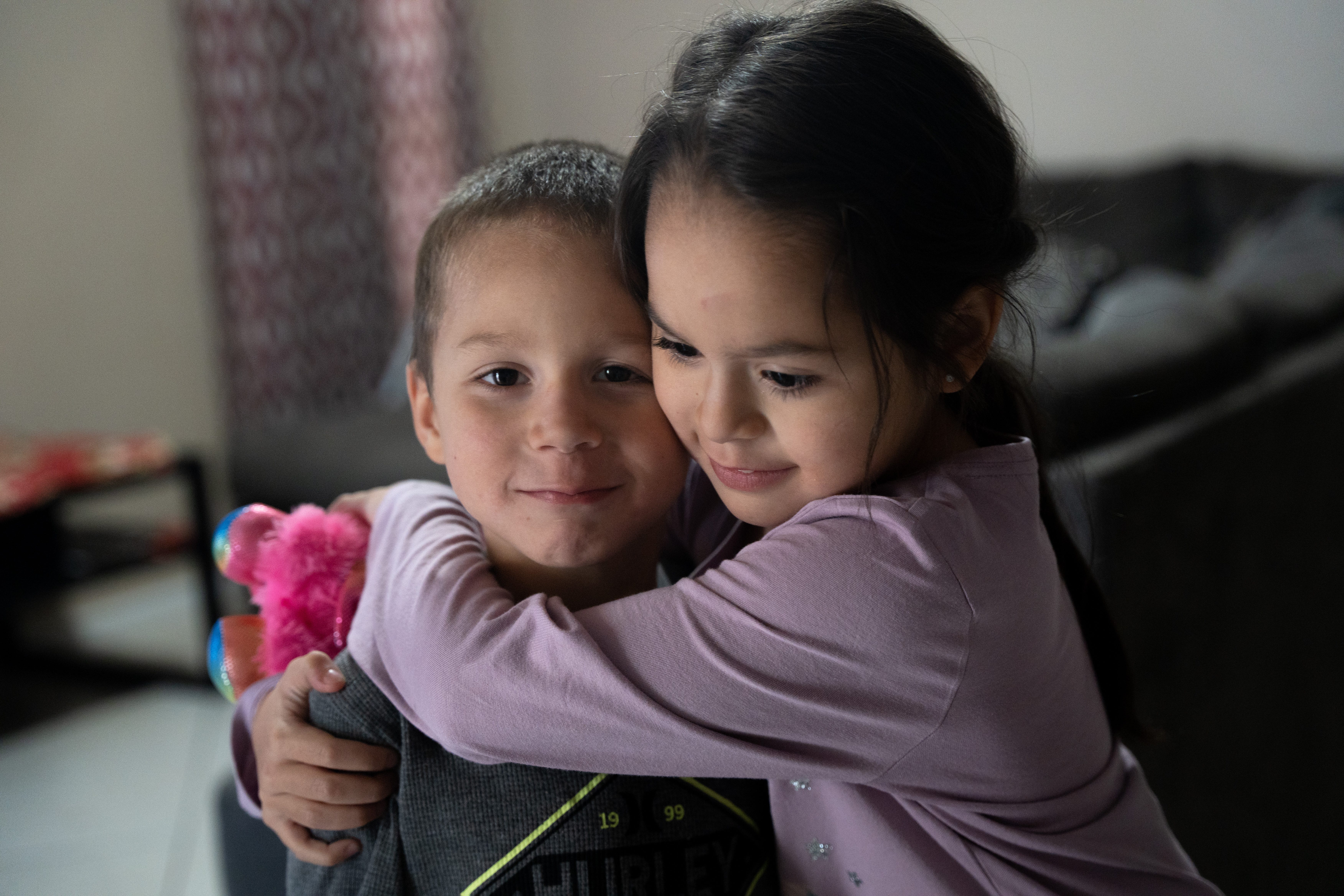 Alvira Arvizo hugs her younger brother, Adriel Arvizo, at their temporary Avondale home on Nov. 18, 2022.