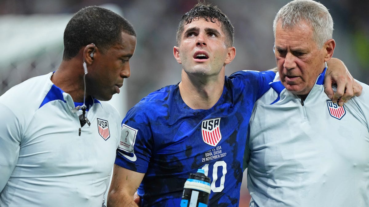 Christian Pulisic is helped to the sideline after colliding with Iran goalkeeper Alireza Beiranvand following his goal in the first half Tuesday.