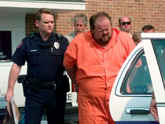FILE - Officials escort murder suspect Alan Eugene Miller away from the Pelham City Jail in Alabama, Aug. 5, 1999. Miller was sentenced to death after being convicted of a 1999 workplace rampage. According to the terms of a settlement agreement approved on Monday, Nov. 28, 2022, Alabama will not seek another lethal injection date for Miller, an inmate whose September execution had been halted because of problems establishing an intravenous line. (AP Photo/Dave Martin, File)