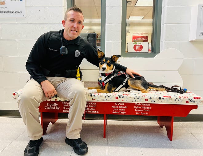 Hingham Police Department School Resource Officer Thomas Ford works with his comfort dog, Opry, at Hingham High School.