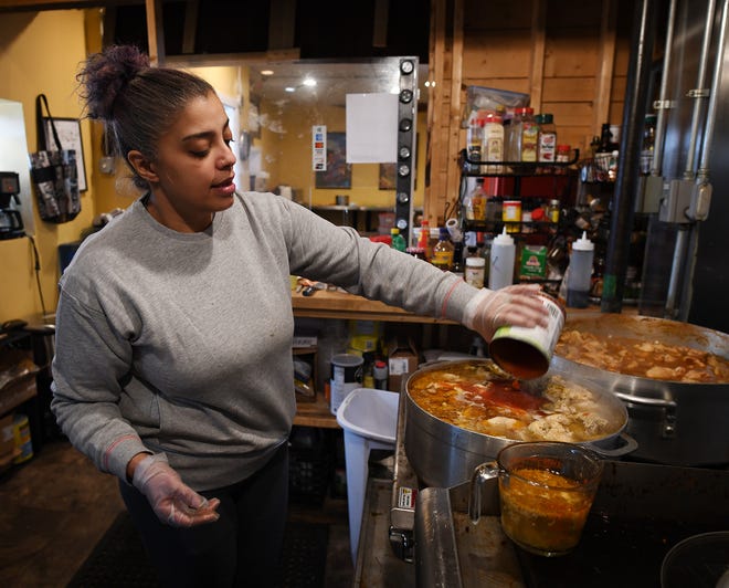 Jessica Reyes-Lambert cooks food for the displaced Plumley Village  residents Thursday.