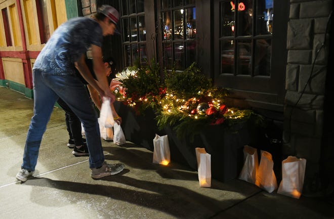Jeremy Schwarb, 16, belakang, dari Oxford dan Noah Wehner, 15, depan, dari Danau Orion meletakkan tokoh-tokoh terkenal di depan Oxford Tap House di Oxford pada 30 November 2022. Tokoh-tokoh terkenal dinyalakan dan dipajang di Oxford untuk mengenang empat siswa tewas satu tahun lalu di Oxford High School.