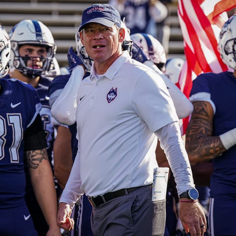 Connecticut coach Jim Mora walks the sideline befo